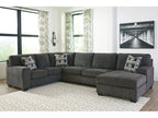 Gray sectional sofa with patterned cushions in a living room setting.