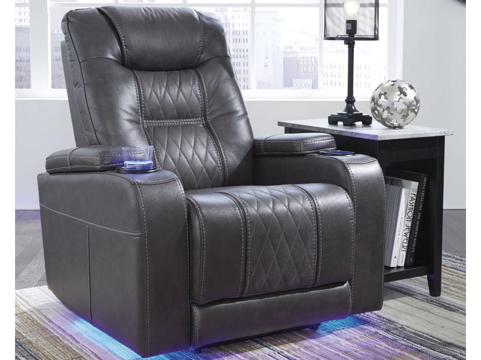 Black leather recliner chair in a room with a side table and decor items.